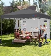 Grande tente extérieure à baldaquin escamotable grise installée dans le jardin. Famille dégustant un repas à la table en bois située en dessous. Un homme fait des grillades à proximité. Fournit de l'ombre pour les activités de plein air.