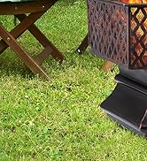 Scène extérieure avec des meubles pliants en bois et une lanterne décorative en métal sur l'herbe. Parties des chaises et de la lanterne visibles dans le cadre.