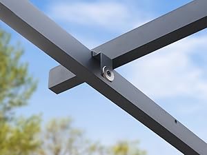 Gros plan de la jonction d'une traverse en métal gris foncé avec le matériel de montage, sur fond de ciel bleu. Détail de la construction industrielle.