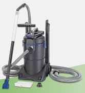 Aspirateur industriel avec corps cylindrique gris et bleu, long tuyau flexible et accessoires de nettoyage, y compris une brosse à sol. L'unité semble robuste avec des roues pour la mobilité.