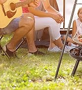 une famille assise autour d'un feu de camp avec une guitare