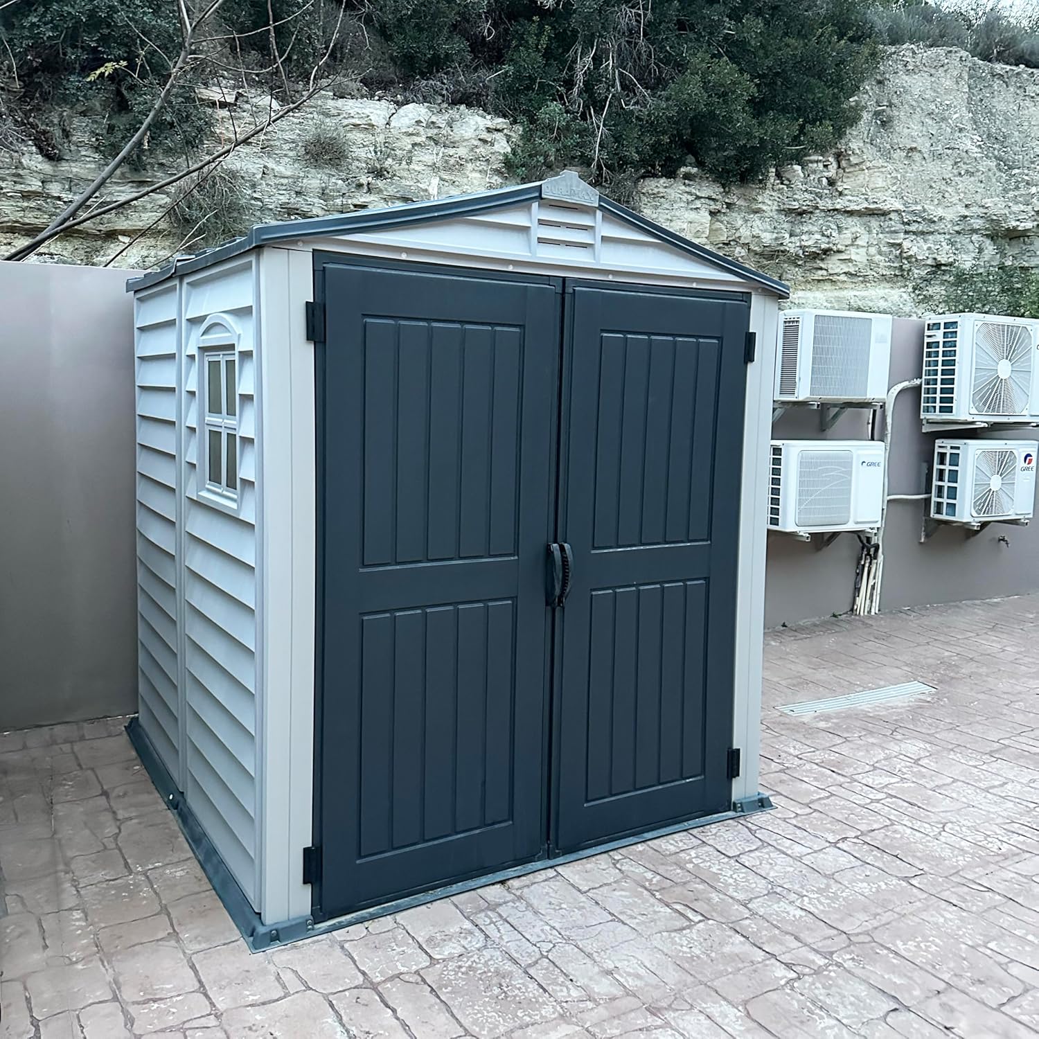 Duramax StoreMate PLUS 6 x 6 (3.65 m²) Abri de jardin en plastique avec plancher en plastique robuste et 1 fenêtre fixe, structure de toit en métal robuste, sans entretien, Gris foncé/ Adobe