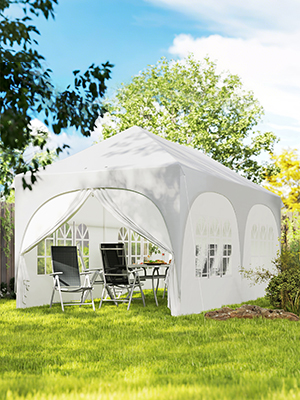 Tente extérieure blanche à baldaquin avec toit voûté et fenêtres multiples, installée sur l'herbe avec chaises de jardin à l'intérieur. Entouré d'arbres et d'un ciel bleu, avec une structure de belvédère portable.