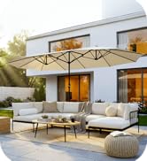 Scène de terrasse extérieure avec canapé sectionnel rembourré blanc avec poufs en tricot beige et grand parasol rectangulaire de couleur crème. L'extérieur moderne de la maison blanche est visible en arrière-plan.