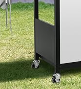 Partie inférieure d'un cadre d'armoire en métal ou en plastique noir avec roues montées, illustrée sur une surface en gazon.