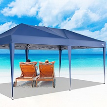 sur une plage avec deux chaises longues oranges en dessous. Ciel clair et océan visibles en arrière-plan.