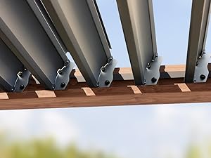 Pergola métallique ou structure d'ombrage montrant des lattes d'aluminium gris montées sur une poutre de support en bois, vue de dessous sur un ciel bleu