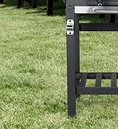 Gros plan d'un pied ou d'un cadre de meuble d'extérieur en métal noir sur de l'herbe, montrant les détails de la structure et le matériel de montage
