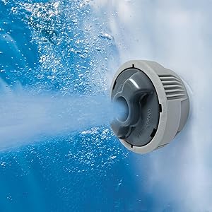 Buse à jet circulaire grise dans une piscine ou un spa, pulvérisant de l'eau sur un fond bleu avec des bulles visibles.