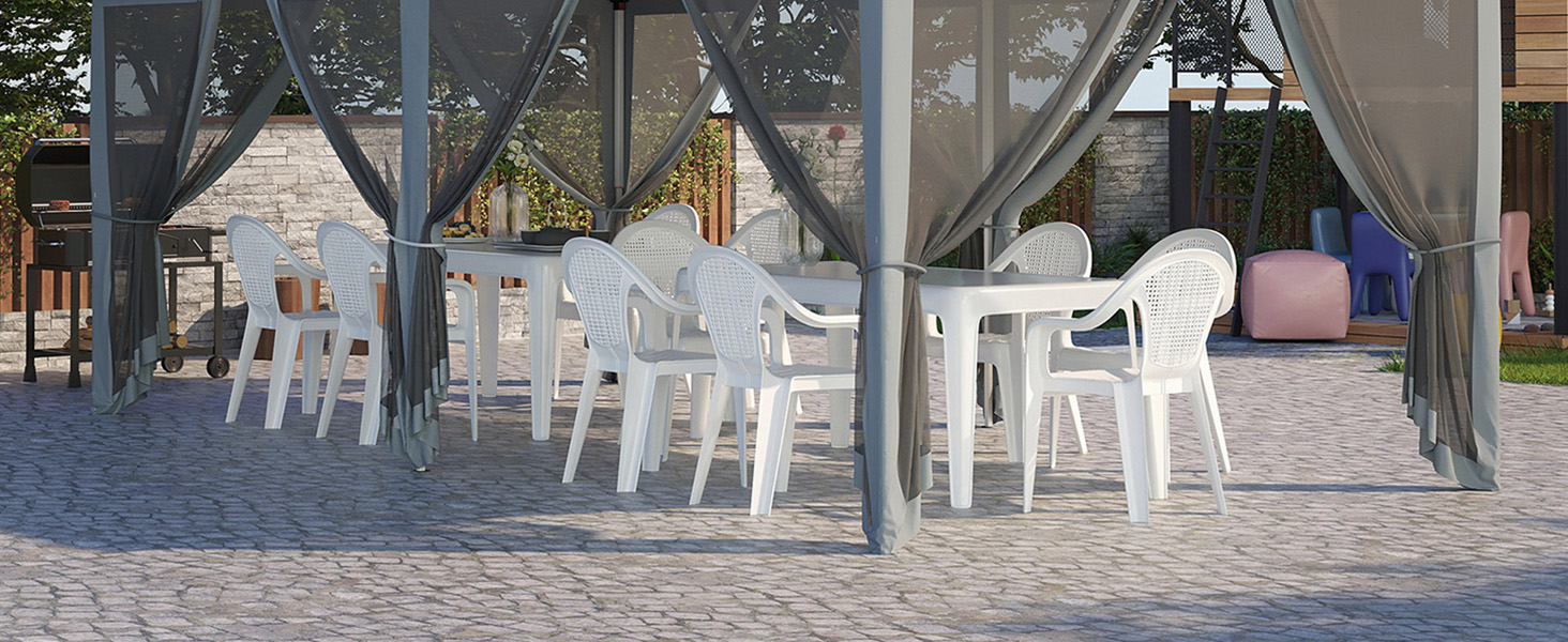Terrasse extérieure avec tables et chaises en plastique blanc sous un auvent gris. Sol en pierre et verdure visibles en arrière-plan.