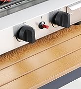 Gros plan d'un panneau de commande d'appareil en acier inoxydable avec deux gros boutons noirs, un petit bouton rouge et un indicateur d'alimentation. Monté sur une surface en bois.