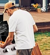 Personne en t-shirt blanc et casquette en train de griller à l'extérieur, avec un ballon de soccer et de l'herbe visibles en arrière-plan