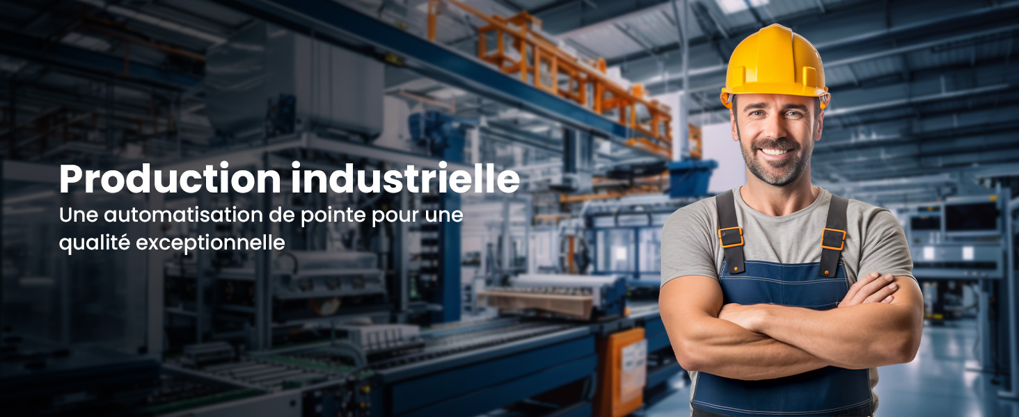 Installation de production industrielle avec machines automatisées. Travailleur au premier plan portant un casque de sécurité, une salopette et debout, les bras croisés, dans un environnement de fabrication