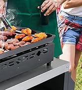Surface de gril extérieure noire avec cuisson de la viande et des légumes, laissant apparaître de la fumée s'élevant des aliments. Vue partielle du panneau latéral ventilé du gril visible.