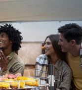 Un groupe d'amis s'est réuni autour d'une table avec de la nourriture, partageant un moment de dîner décontracté ensemble.