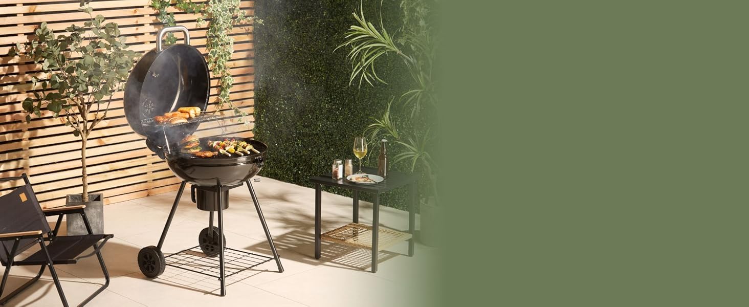 Scène de terrasse extérieure avec barbecue sphérique noir, petite table d'appoint et écran d'intimité en bambou.