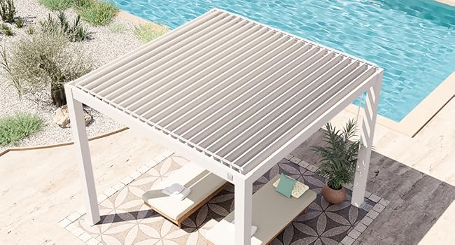 Pergola extérieure blanche moderne avec toit à lattes, positionnée près d'une piscine. Il présente des lignes épurées et dispose d'un coin salon ombragé sur un tapis d'extérieur à motifs