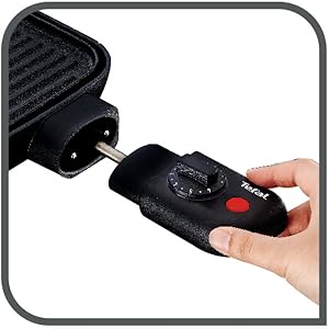 Séquence rapprochée montrant la poignée noire de l'appareil sur laquelle on appuie ou que l'on règle le mécanisme à boutons rouges.