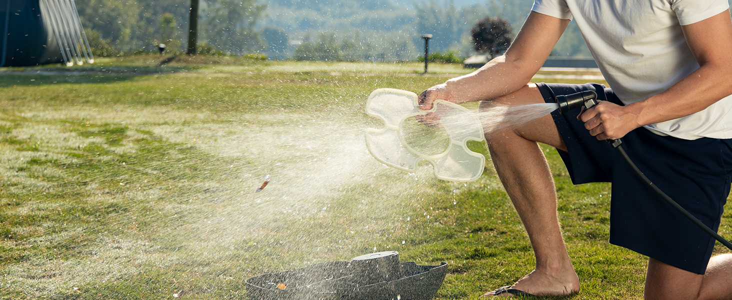 Personne portant un short noir et une manche de couleur claire utilisant un smartphone à l'extérieur sur l'herbe, avec un mouvement de course ou athlétique suggéré par la position.