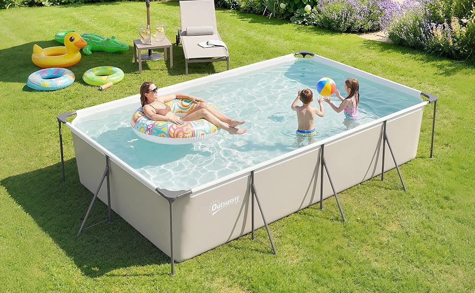 Piscine hors sol rectangulaire avec cadre blanc et eau bleu clair. Plusieurs personnes nagent. Situé sur une pelouse verte avec des chaises longues jaunes et des plantes visibles en arrière-plan.