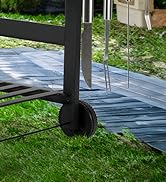 Gros plan d'une terrasse ou d'un coin de patio montrant un poteau de balustrade en métal noir sur des planches de bois. De l'herbe verte est visible en dessous.