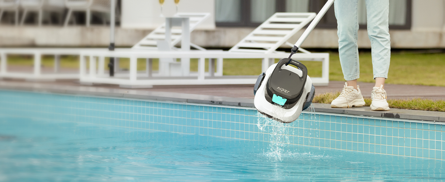 Les pieds de la personne portent des chaussettes blanches et des chaussures foncées au bord de la piscine, plongeant une montre intelligente dans l'eau bleue de la piscine, démontrant ainsi sa capacité d'étanchéité.