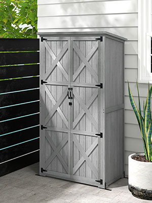 Unité de rangement extérieure avec portes en forme de grange à motif en X au fini gris patiné, positionnée contre le mur extérieur avec une balustrade visible.