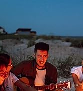 amis jouant de la guitare au coin du feu