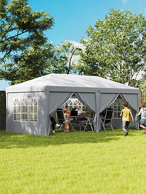 Grande tente de pavillon extérieure grise installée sur l'herbe. Comprend des fenêtres, un toit en pointe et des parois latérales. Les personnes visibles à l'intérieur l'utilisent pour se rassembler et s'asseoir.
