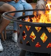 Foyer extérieur avec des découpes géométriques en losange qui brillent des flammes à l'intérieur, illustré en cours d'utilisation