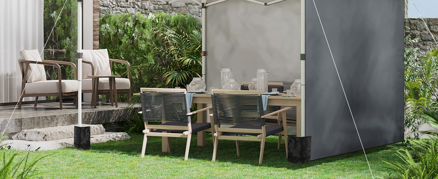 une table et des chaises sous une tente dans un jardin.