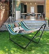en tissu rayé bleu et vert suspendu à un cadre en métal noir, positionné sur une pelouse avec le patio de la maison visible
