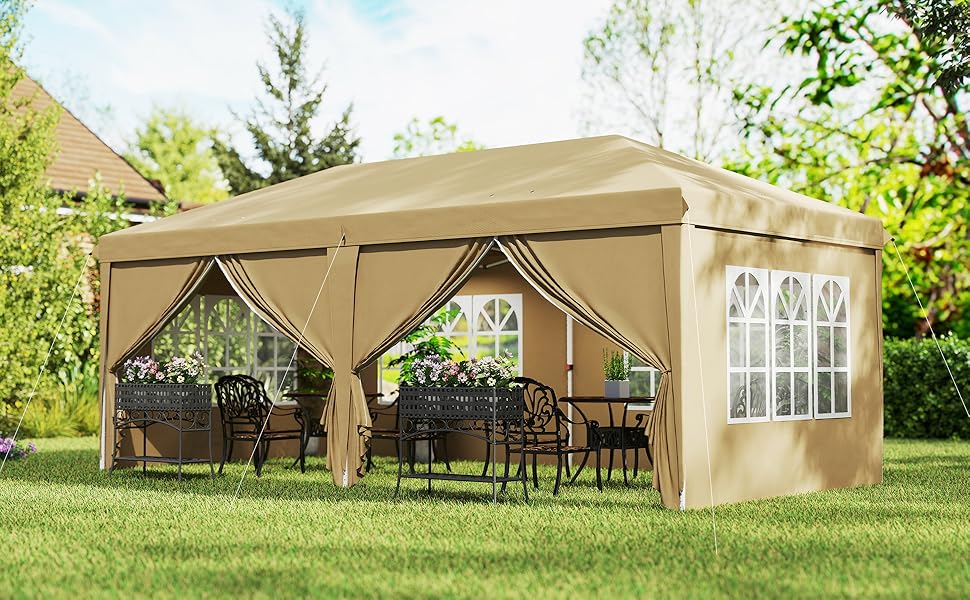 Grande tente extérieure à baldaquin beige avec panneaux latéraux et fenêtres. Installé sur la pelouse, il contient des meubles de patio et constitue un abri pour les rassemblements ou les événements en plein air.