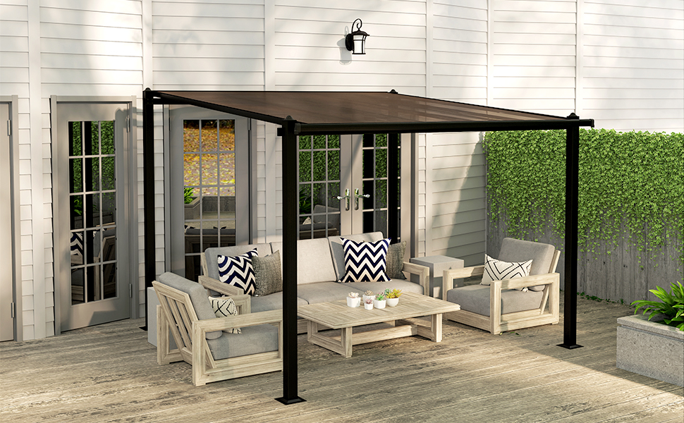 Terrasse extérieure avec pergola, meubles en bois blanc et coussins. Attenant à la maison avec portes-fenêtres, bordé par une haie