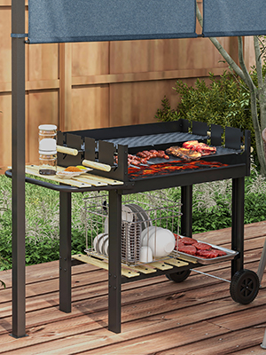 sur roulettes avec cuisson des aliments sur des grilles. L'étagère inférieure contient des assiettes. Terrasse en bois et clôture visibles en arrière-plan.