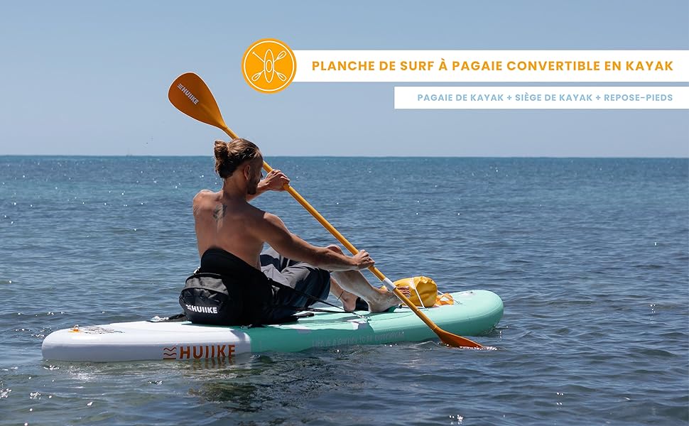 un homme pagaie sur une planche à pagaie sur l'eau