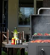 Scène de barbecue en plein air avec de la viande cuite sur des grilles, accompagnée de boissons et de condiments sur une table d'appoint