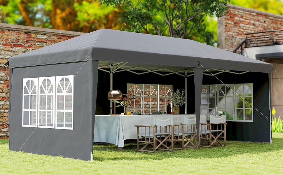 Vues extérieures d'un bâtiment modulaire gris foncé ou anthracite ou d'une structure portable dans un cadre extérieur avec de l'herbe et des arbres.